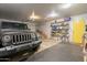 Spacious garage with overhead lighting, a parked Jeep, storage shelves, and a rolling door at 907 N Mountain Rd, Mesa, AZ 85207