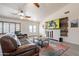Inviting living room featuring a mounted television, wood-style tile, and shuttered windows at 907 N Mountain Rd, Mesa, AZ 85207