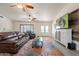 Open-concept living room features neutral walls, wood-style tile, and a large TV at 907 N Mountain Rd, Mesa, AZ 85207