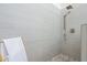 Modern shower featuring sleek gray tiling, rainfall shower head, and river rock flooring at 907 N Mountain Rd, Mesa, AZ 85207