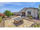 Backyard with a covered patio and desert landscaping featuring a fire pit and outdoor grill area at 10350 E Texas Ave, Mesa, AZ 85212