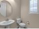 Powder room features a pedestal sink and a large round mirror at 10350 E Texas Ave, Mesa, AZ 85212