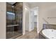 Bathroom featuring a glass shower with seat and dual showerheads, a tub, and grab bars at 10350 E Texas Ave, Mesa, AZ 85212