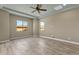 Spacious bedroom with wood-style tile flooring, a ceiling fan, and bright windows at 10350 E Texas Ave, Mesa, AZ 85212