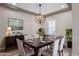 Elegant dining room features modern chandelier, buffet, and plantation shutters for a bright, inviting space at 10350 E Texas Ave, Mesa, AZ 85212