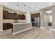Open kitchen with a central island, stainless steel appliances and dark wood cabinets at 10350 E Texas Ave, Mesa, AZ 85212