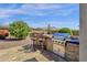 Outdoor kitchen with a built-in grill, bar seating, and well-manicured landscaping at 10350 E Texas Ave, Mesa, AZ 85212