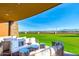 Covered patio with comfortable seating area offers serene views of the beautifully maintained lawn and distant mountains at 10350 E Texas Ave, Mesa, AZ 85212