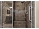 Close-up of a walk-in shower with seat, glass doors, and decorative tile accents at 10350 E Texas Ave, Mesa, AZ 85212