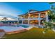 Lush backyard featuring a pool, manicured lawn, and a view of the elegant two-story home at 1234 E Claire Dr, Phoenix, AZ 85022