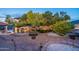 Lush backyard with a stone fountain, covered patio, inviting pool, and mature trees for ultimate relaxation and entertaining at 1234 E Claire Dr, Phoenix, AZ 85022