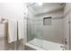 Tiled shower with glass door, built-in niche, and modern fixtures at 1234 E Claire Dr, Phoenix, AZ 85022