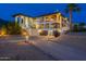 Two-story home with a three car garage, desert landscaping, and an illuminated driveway at 1234 E Claire Dr, Phoenix, AZ 85022