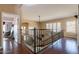 Elegant hallway with wrought iron railing and hardwood floors, leading to other living spaces at 1234 E Claire Dr, Phoenix, AZ 85022