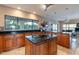 Gourmet kitchen featuring wood cabinetry, cooktop island and tile floors at 1234 E Claire Dr, Phoenix, AZ 85022