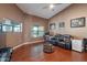 Comfortable living room with a ceiling fan, high ceilings, hardwood floors, and natural lighting from the windows at 1234 E Claire Dr, Phoenix, AZ 85022