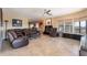 Spacious living room with leather seating, fireplace, and large windows offering scenic views, all under a modern ceiling fan at 1234 E Claire Dr, Phoenix, AZ 85022
