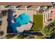 Aerial close up of the backyard's stunning pool with its surrounding patio, outdoor fireplace, and green space at 1234 E Claire Dr, Phoenix, AZ 85022