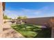 Inviting backyard featuring artificial turf, a brick patio, pool, and stylish outdoor furniture at 13155 W Monterey Way, Litchfield Park, AZ 85340