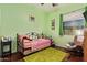 Inviting bedroom with green walls, trundle daybed, dresser, and cozy rocking chair at 13155 W Monterey Way, Litchfield Park, AZ 85340