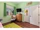 Bedroom with green walls, hard floors, dresser, rocking chair, and white bi-fold closet door at 13155 W Monterey Way, Litchfield Park, AZ 85340