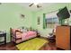 Inviting bedroom with green walls, trundle daybed, dresser, and cozy rocking chair at 13155 W Monterey Way, Litchfield Park, AZ 85340