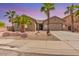 Charming single-story home featuring a two-car garage and desert landscaping with mature palm trees at 13155 W Monterey Way, Litchfield Park, AZ 85340