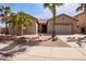 Well-maintained home showcasing desert landscaping, mature palm trees, and a spacious two-car garage at 13155 W Monterey Way, Litchfield Park, AZ 85340