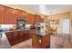 Well-equipped kitchen with dark wood cabinets, granite countertops, an island, and a cozy breakfast nook at 13155 W Monterey Way, Litchfield Park, AZ 85340