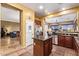 Well-lit kitchen with granite countertops, an island, and a view to the living and dining area at 13155 W Monterey Way, Litchfield Park, AZ 85340