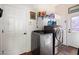 Well-equipped laundry room with modern washer and dryer, shelving, and convenient access to outdoor area at 13155 W Monterey Way, Litchfield Park, AZ 85340