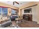 Cozy living room with a fireplace, a large TV, and a sliding glass door with backyard views at 13155 W Monterey Way, Litchfield Park, AZ 85340