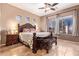 Spacious main bedroom featuring tile floors, a large window, and a decorative wooden bed frame at 13155 W Monterey Way, Litchfield Park, AZ 85340