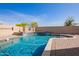 Sparkling pool with baja step and raised water feature set in a desert landscape at 13155 W Monterey Way, Litchfield Park, AZ 85340