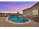 Backyard swimming pool with a waterfall feature, brick pavers, and desert landscaping at 13155 W Monterey Way, Litchfield Park, AZ 85340