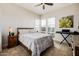 A bedroom featuring a bed, end table, and keyboard with natural light from the window at 1341 E Paseo Way, Phoenix, AZ 85042