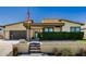 Front exterior of home with a flag pole, lush green bushes, and a blue front door at 1341 E Paseo Way, Phoenix, AZ 85042