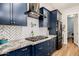 Modern kitchen showcasing navy cabinets, stainless steel appliances, and elegant tile backsplash at 1341 E Paseo Way, Phoenix, AZ 85042