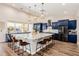 A large kitchen features a massive island with bar stool seating, dark blue cabinets, and modern appliances at 1341 E Paseo Way, Phoenix, AZ 85042