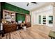 A home office features a custom wood bookcase, desk, and a large grass-covered accent wall at 1341 E Paseo Way, Phoenix, AZ 85042