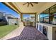 A covered outdoor kitchen features a built-in grill, counter seating, and a mini fridge at 1341 E Paseo Way, Phoenix, AZ 85042