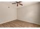 Spacious bedroom with wood-look flooring, neutral walls, and ceiling fan at 14250 W Wigwam Blvd # 2111, Litchfield Park, AZ 85340