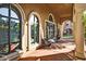 Welcoming building entrance featuring large arch windows, decorative potted plants, and covered walkway at 14250 W Wigwam Blvd # 2111, Litchfield Park, AZ 85340