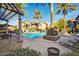 Community swimming pool surrounded by palm trees, lounge chairs, and well-maintained landscaping at 14250 W Wigwam Blvd # 2111, Litchfield Park, AZ 85340
