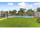 Backyard featuring a pool with a safety fence, synthetic grass, and mature landscaping at 14554 W Evans Dr, Surprise, AZ 85379