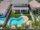 Aerial view of a stunning backyard featuring a pool, artificial grass, covered patio, and a secure fence for privacy at 14554 W Evans Dr, Surprise, AZ 85379