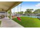 Backyard featuring a covered patio, artificial turf, swimming pool, and mature landscaping at 14554 W Evans Dr, Surprise, AZ 85379
