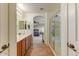 Bright bathroom with double sinks, tile floors, glass shower, and open access to bedroom at 14554 W Evans Dr, Surprise, AZ 85379