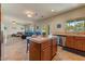 Bright open kitchen featuring wood cabinets, tiled floors, island, and easy access to the living room at 14554 W Evans Dr, Surprise, AZ 85379