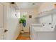 Functional laundry room equipped with washer, dryer, shelving and a small window at 14554 W Evans Dr, Surprise, AZ 85379